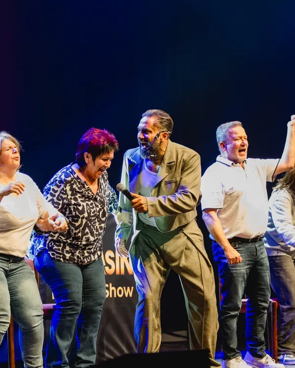 Teilnehmer lachen und jubeln gemeinsam mit Mr.Yasin auf der Bühne
