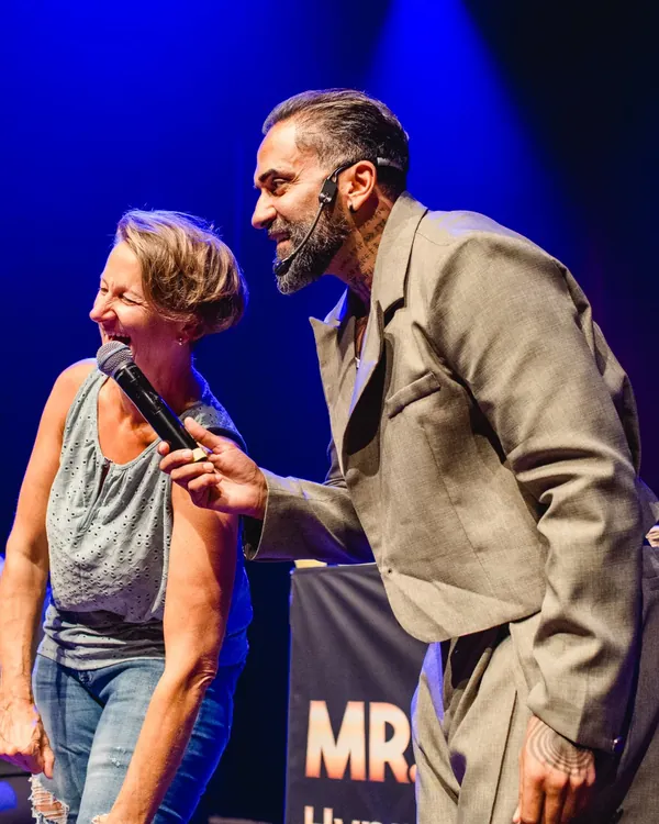Eine Teilnehmerin lacht ins Mikrofon, das Mr.Yasin ihr hinhält